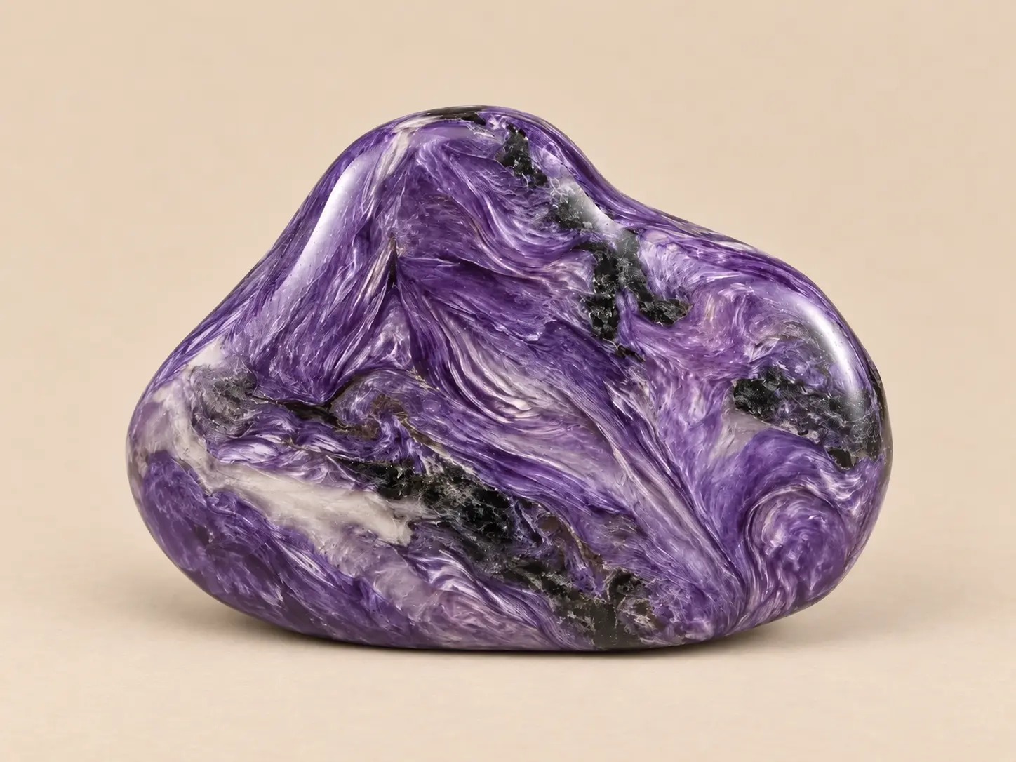 Volledig zichtbare gepolijste violette charoiët met witte en zwarte wervelpatronen